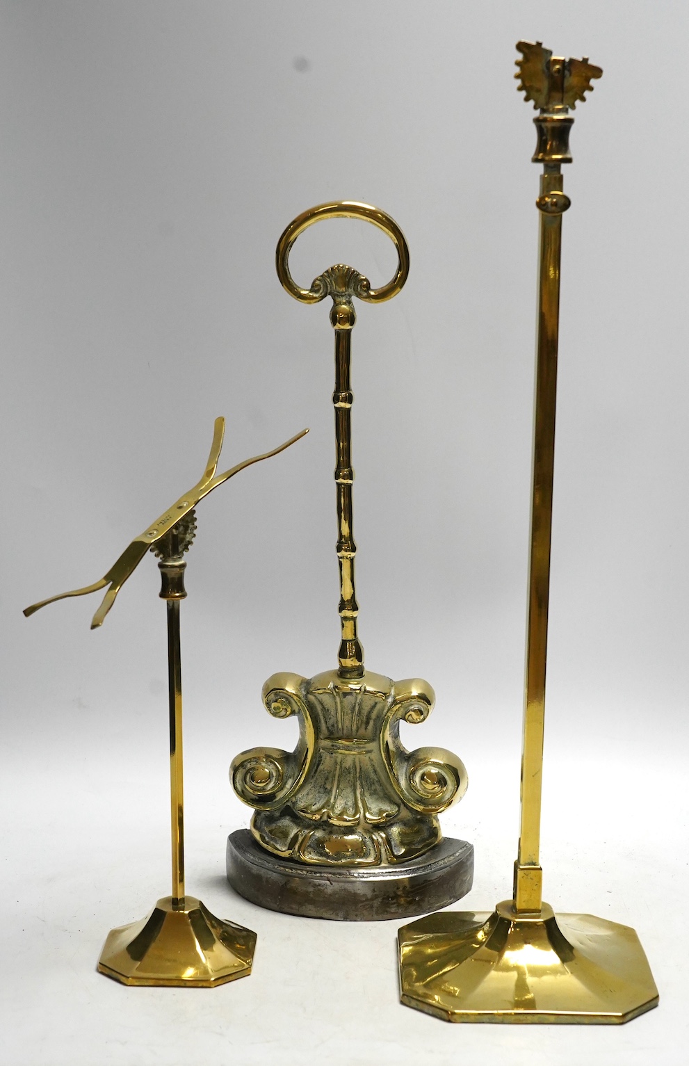 A Victorian brass door porter and two brass stands, tallest stand 45cm high